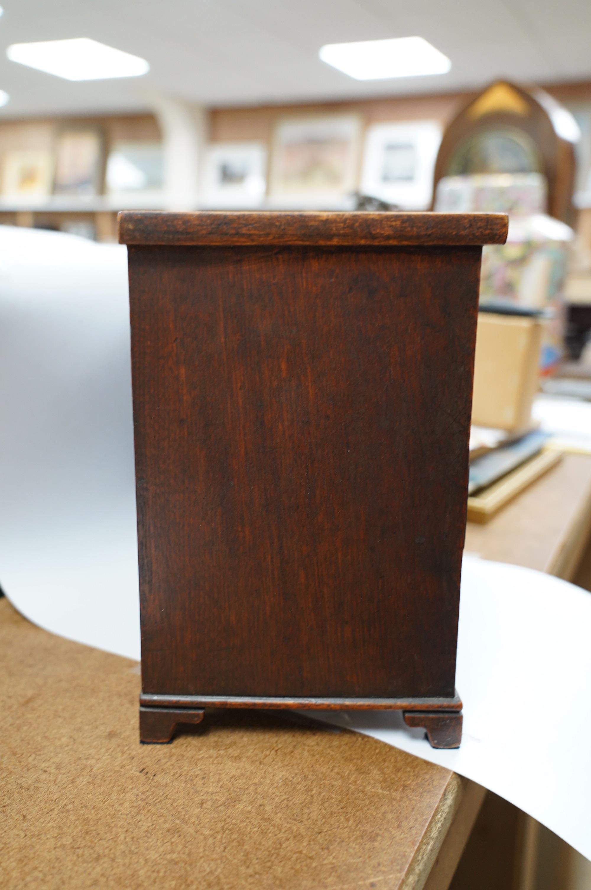 A miniature mahogany three long, two short, chest of drawers 32cms wide. Condition - good